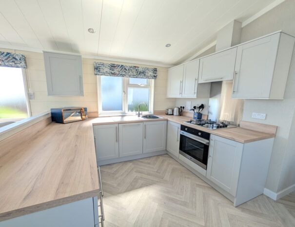 A modern kitchen with fridge freezer, dishwasher, washing machine.