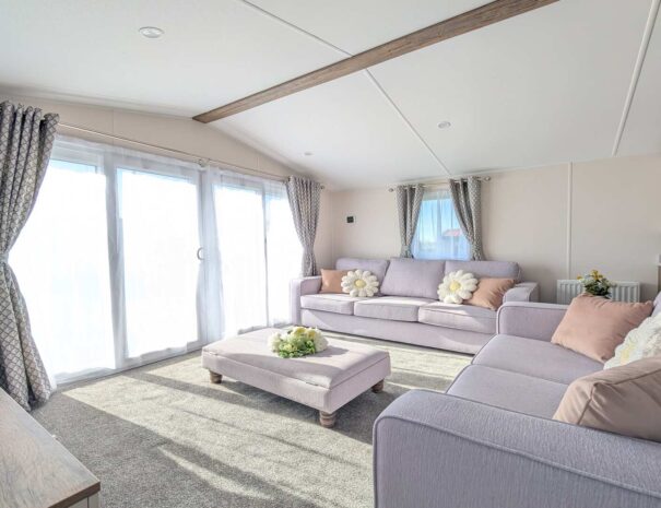 A cosy lounge with 2 sofas with front aspect french doors.