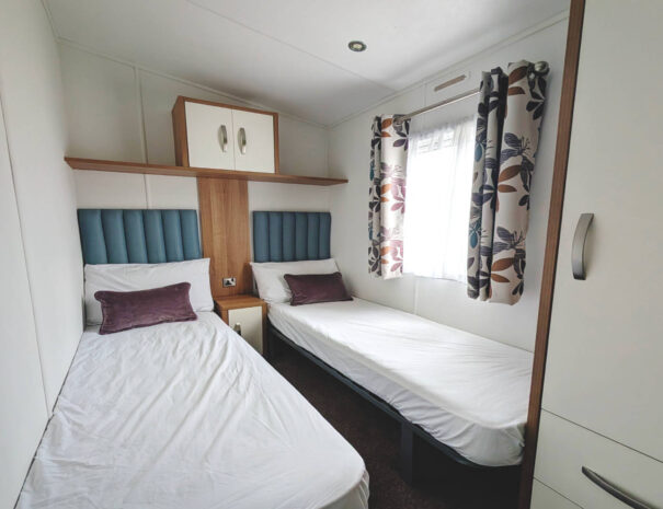Cozy twin bedroom with built in cupboards.